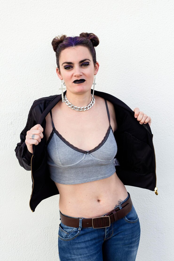 Foto uma mulher com uma tatuagem no peito está vestindo uma camisola cinzenta