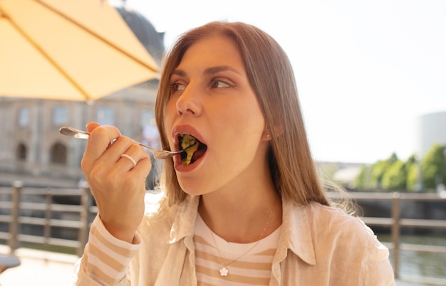 Uma mulher come uma refeição em um restaurante.