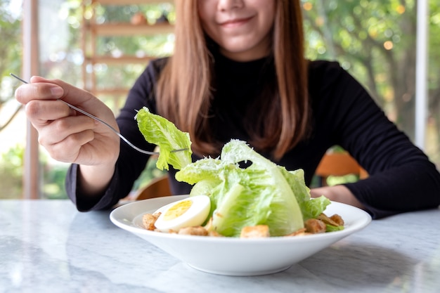 Foto uma mulher comendo salada césar