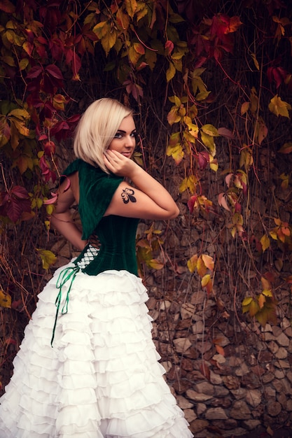 Uma mulher como uma princesa em um vestido vintage no parque de fadas