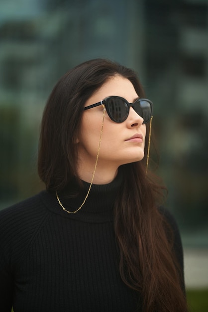 Uma mulher confiante e bonita usa óculos de sol caros Conceito de acessórios de luxo para mulheres Menina morena estilosa na cidade
