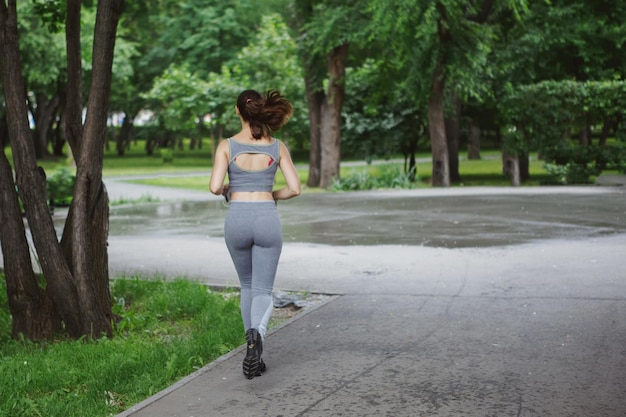 Uma mulher corredora morena corre no parque correndo