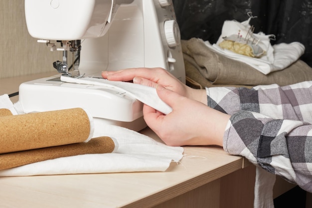 Uma mulher costura uma sacola de compras feita de algodão e cortiça com uma máquina de costura