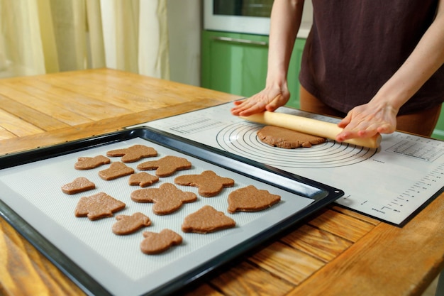 Uma mulher cozinhando biscoitos caseiros de férias em um tapete de silicone