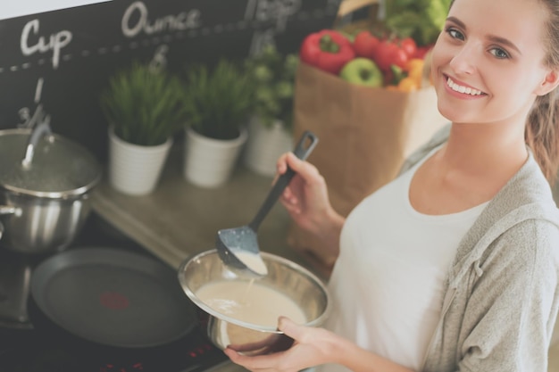 Uma mulher cozinhando em uma cozinha com uma placa que diz "maçã"