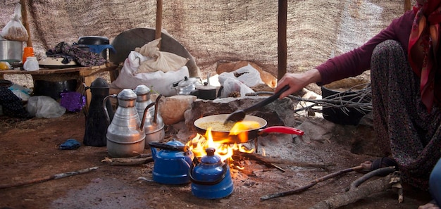 Uma mulher da Anatólia está cozinhando em uma barraca nômade