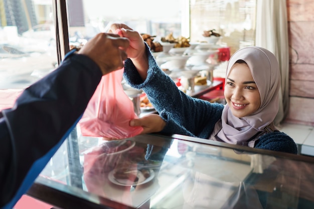 Uma mulher dá um pedido de comida para um homem