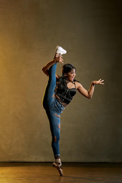 Foto uma mulher de blusa preta e jeans está abrindo as pernas.