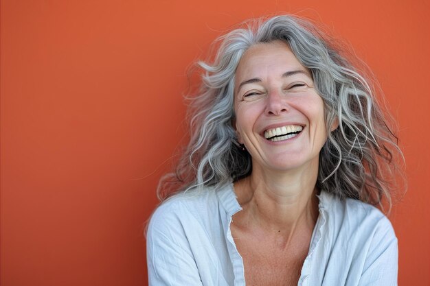 Foto uma mulher de cabelos grisalhos sorrindo e rindo