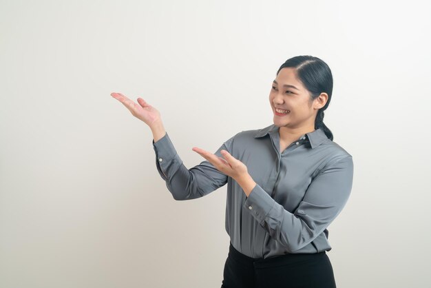 uma mulher de camisa cinzenta está segurando as mãos em frente a um fundo branco