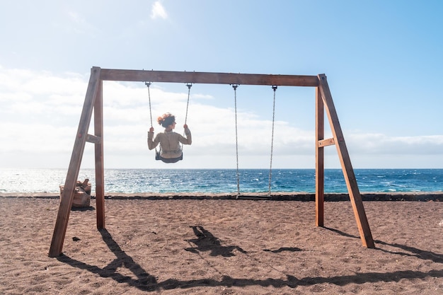 Uma mulher de férias balançando em um balanço na praia da ilha de El Hierro Ilhas Canárias