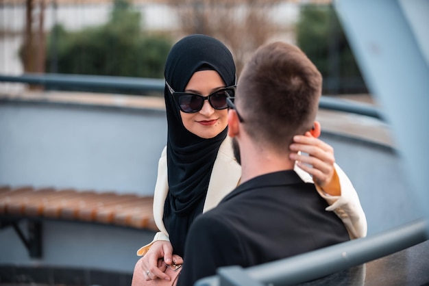 Uma mulher de hijab está conversando com um homem.