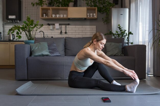 Uma mulher de meia idade está envolvida em exercícios de fitness e esportes em casa