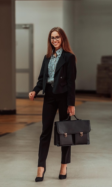 Uma mulher de negócios de terno com uma maleta na mão vai trabalhar Foco seletivo Conceito de negócios Foto de alta qualidade