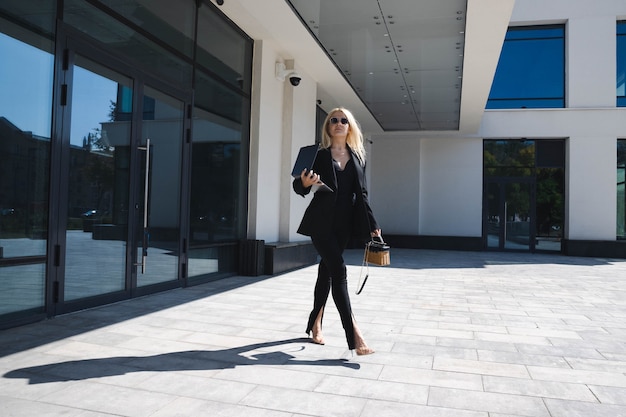 Foto uma mulher de negócios em um terno elegante caminha perto do centro comercial