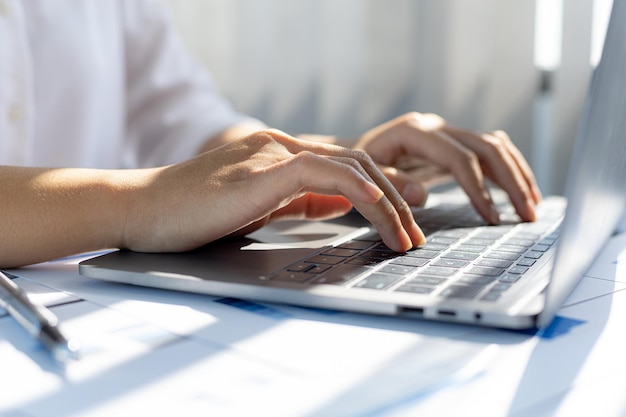 Uma mulher de negócios trabalhando em uma sala privada, ela está digitando em um teclado de laptop, ela usa um mensageiro para conversar com um parceiro. Conceito de uso da tecnologia na comunicação.