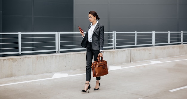 Uma mulher de negócios verifica o smartphone