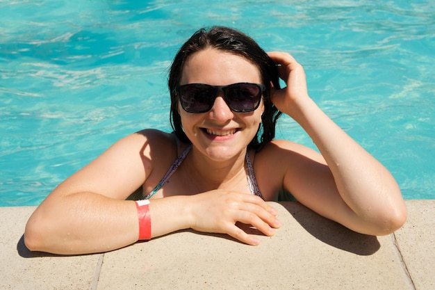 Uma mulher de óculos de sol descansa na piscina