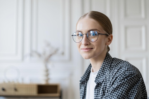 Uma mulher de óculos é uma economista freelance que trabalha usa um laptop faz um relatório para uma empresa de programação