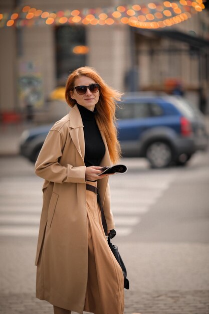 uma mulher de óculos escuros caminha pela rua. caminhar na cidade de outono