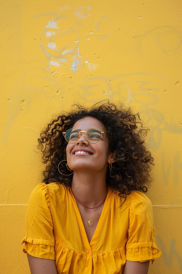 Foto uma mulher de óculos está sorrindo e vestindo uma camisa amarela que diz "frisbee quot"