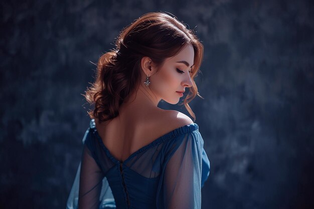 Foto uma mulher de vestido azul está de pé na frente de um fundo escuro