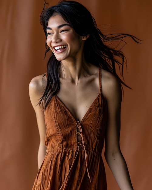 Uma mulher de vestido castanho está sorrindo.