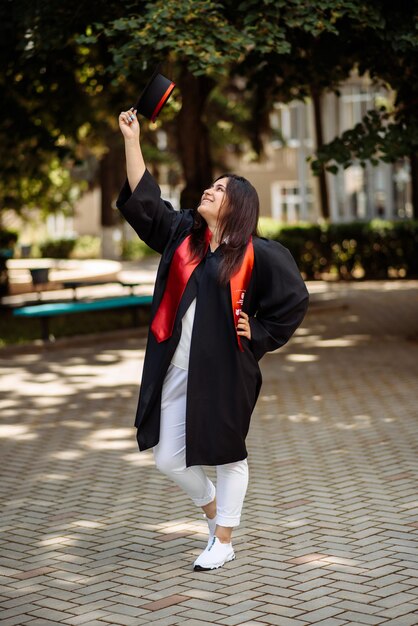 Foto uma mulher de vestido preto e vermelho está segurando um telefone