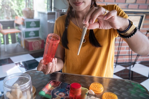 Uma mulher demonstra um baseado de um cigarro com maconha Legalização da maconha na Tailândia