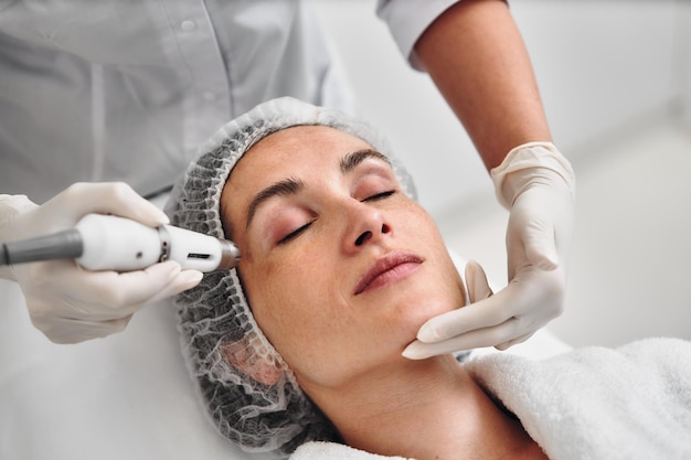 Uma mulher desfruta de um tratamento facial enquanto se deita confortavelmente no spa