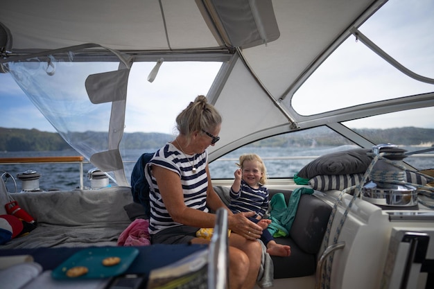 uma mulher e uma criança num barco com uma mulher a segurar um telemóvel