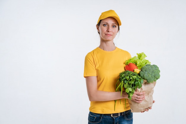 Uma mulher em roupas amarelas, entregando um pacote de comida, sobre um fundo branco