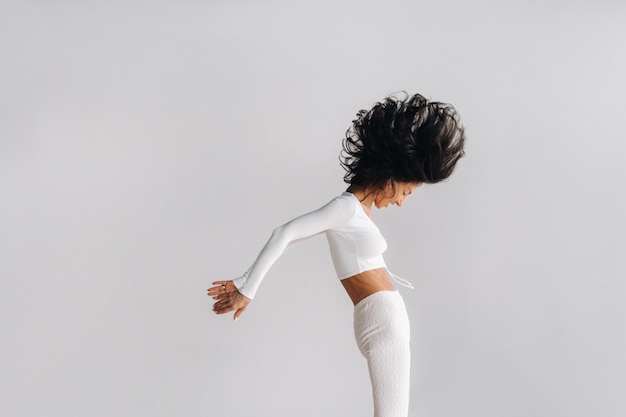 Foto uma mulher em roupas esportivas brancas está envolvida em meditação kali dinâmica no salão de ioga