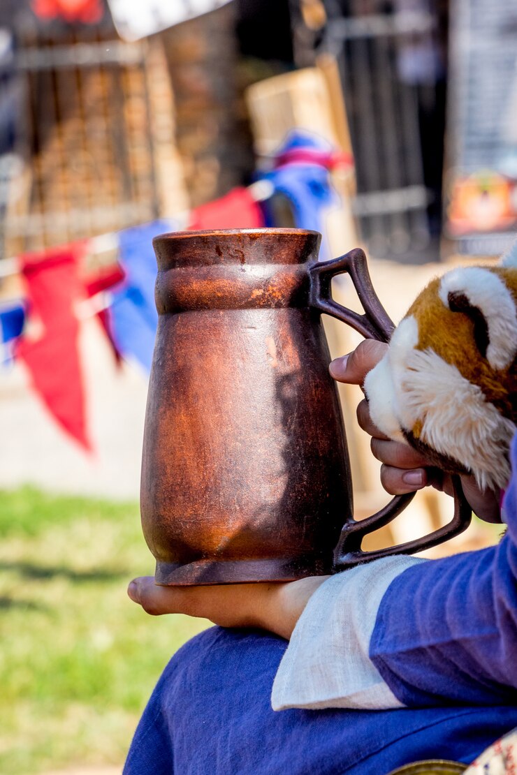 Foto uma mulher em roupas medievais segura uma panela de barro durante o festival