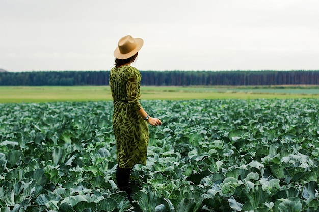 Uma mulher em um campo com época de colheita de outono de repolho