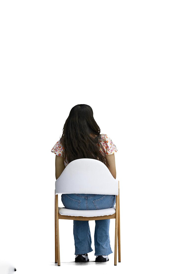 Foto uma mulher em um fundo branco de comprimento inteiro sentada em uma cadeira com vista para trás