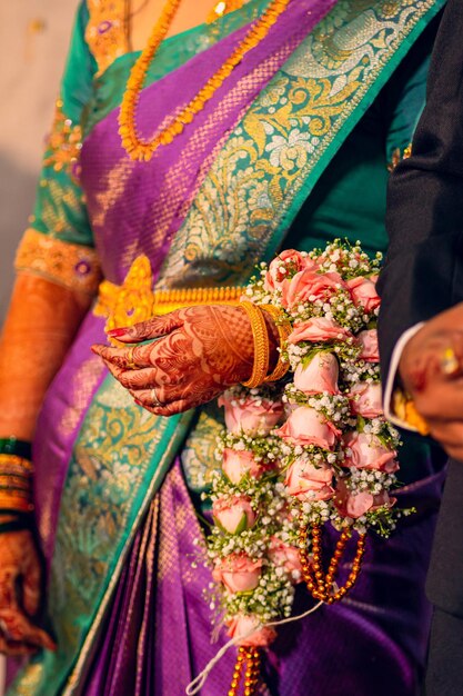 Uma mulher em um sari roxo com flores no braço