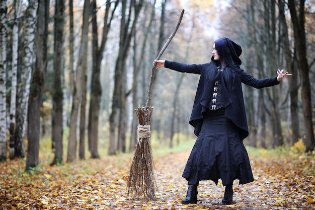 Foto uma mulher em um traje de bruxa em uma floresta densa em um ritual