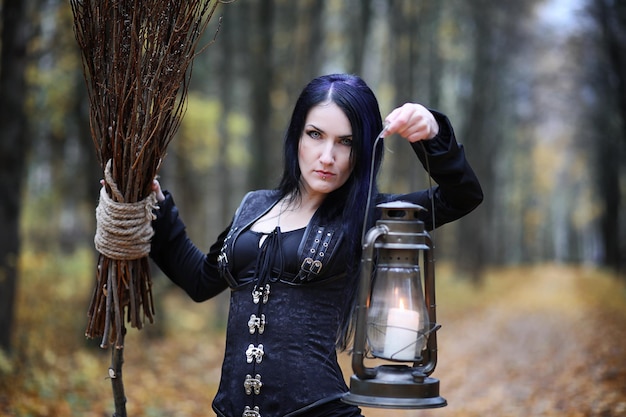 Uma mulher em um traje de bruxa em uma floresta