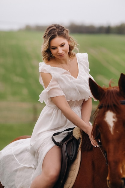 Uma mulher em um vestido branco andando a cavalo em um campo