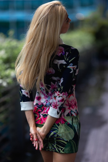 Uma mulher em um vestido floral com um coelho branco na frente