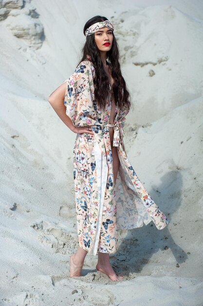 Uma mulher em um vestido floral está em uma praia.