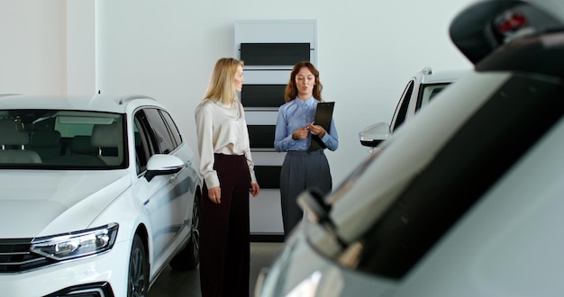 Uma mulher escolhe um carro numa concessionária