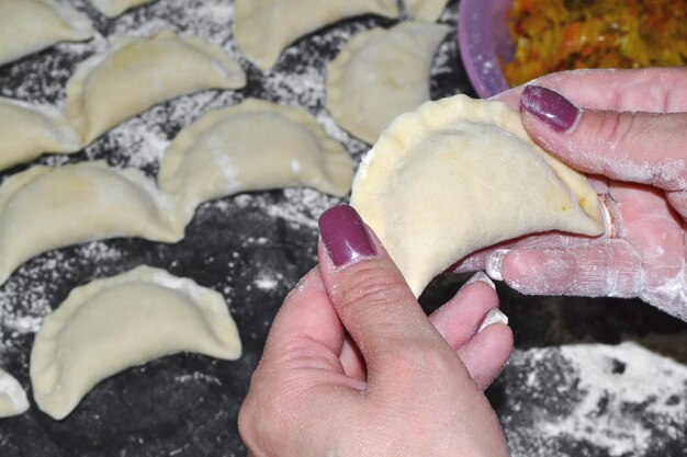 Uma mulher esculpe bolinhos com as mãos.