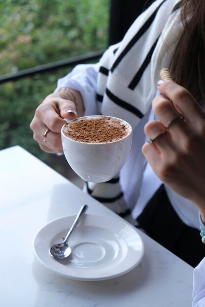 uma mulher está bebendo de uma chávena de café