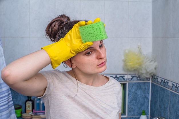 uma mulher está cansada depois de limpar o banheiro.