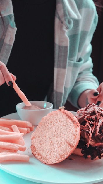 uma mulher está cortando um sanduíche com uma faca e uma tigela de comida