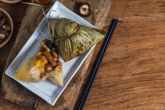 Uma mulher está dando zongzi (bolinho de arroz) para os outros como um presente no dragon boat festival