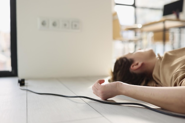 Uma mulher está deitada no chão ao lado dela um fio de um aparelho elétrico um choque de close-up em