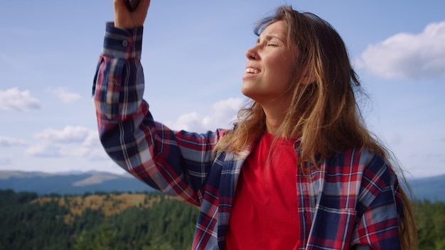 Uma mulher está olhando para cima e olhando para o telefone.